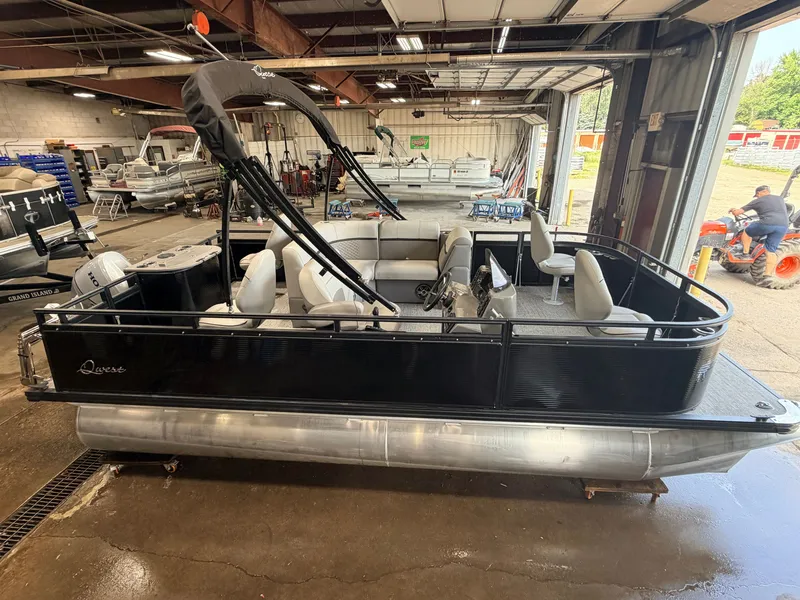 Slide: The Image of A black pontoon boat is in a warehouse. It features multiple seats and a canopy. - 3