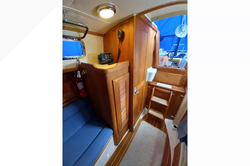 Slide: The Image of Interior of 2002 Pacific Seacraft Dana 24 sailboat with wooden cabinetry and blue seating. - 44