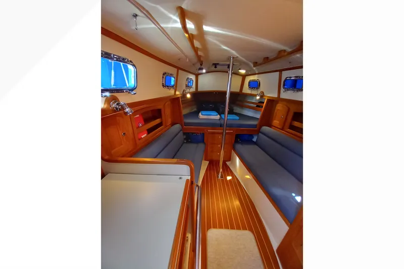 Slide: The Image of Interior of 2002 Pacific Seacraft Dana 24 sailboat with wooden finishes and blue seating. - 53