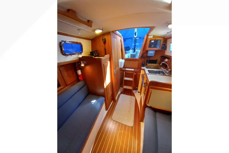 Slide: The Image of Interior of 2002 Pacific Seacraft Dana 24 sailboat, featuring cozy seating and wooden finishes. - 52