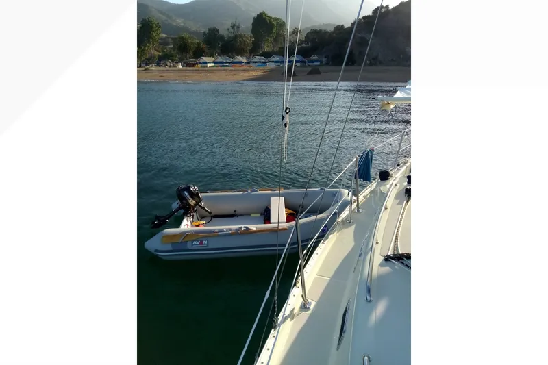 Slide: The Image of Pacific Seacraft Dana 24 sailboat near shore with inflatable dinghy, 2002 model. - 35
