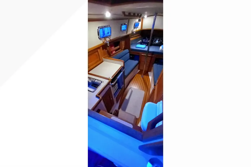 Slide: The Image of Interior of 2002 Pacific Seacraft Dana 24 sailboat, featuring cozy seating and wooden finishes. - 14