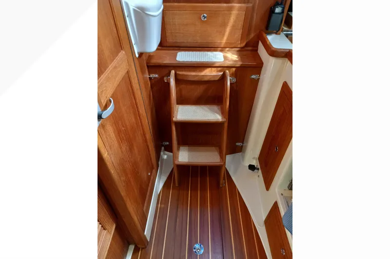 Slide: The Image of Interior of 2002 Pacific Seacraft Dana 24 sailboat with wooden steps and cabinetry. - 24