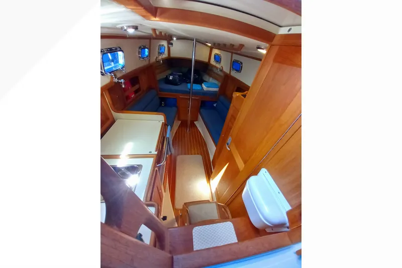 Slide: The Image of Interior of 2002 Pacific Seacraft Dana 24 sailboat, featuring cozy wooden cabin and seating. - 21