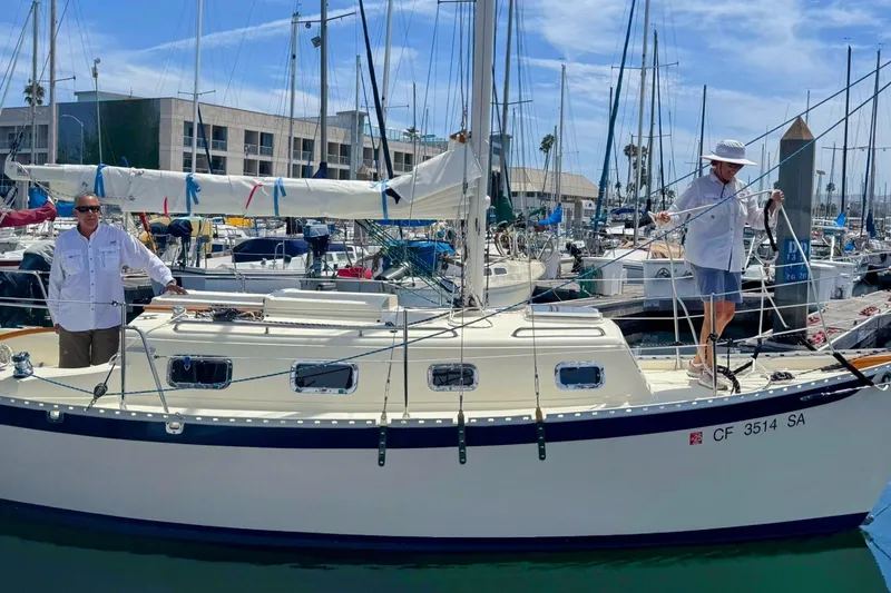 The Image of 2002 Pacific Seacraft Dana 24 sailboat docked with two people on deck. - 0
