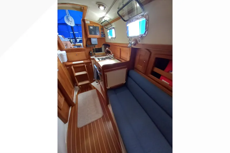 Slide: The Image of Interior of 2002 Pacific Seacraft Dana 24 sailboat with wooden cabinetry and blue seating. - 45