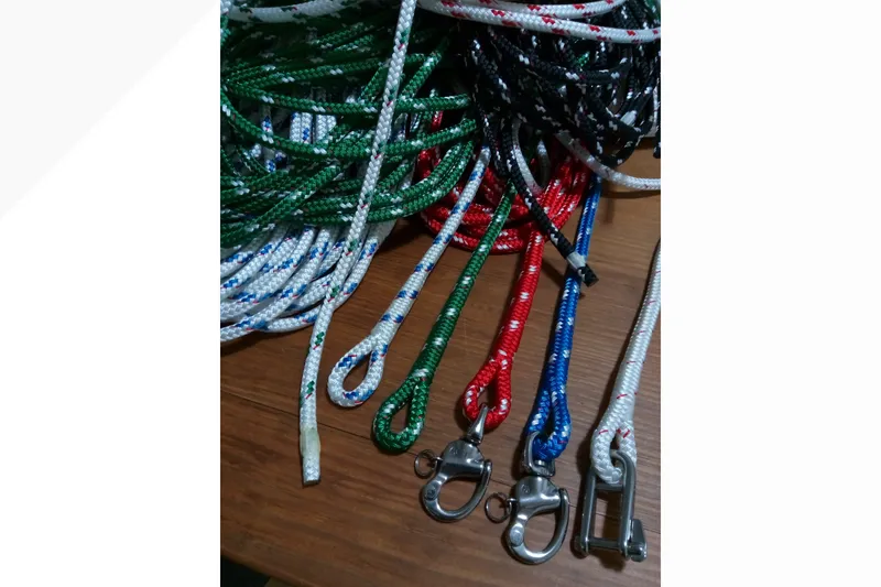 Slide: The Image of Colorful sailing ropes and hardware for a 2002 Pacific Seacraft Dana 24 on wooden surface. - 27