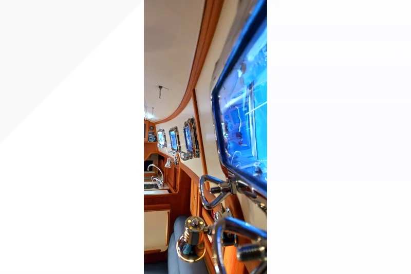 Slide: The Image of Interior view of 2002 Pacific Seacraft Dana 24 sailboat, showcasing portholes and wooden finish. - 38