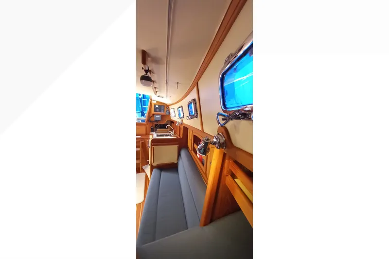 Slide: The Image of Interior of 2002 Pacific Seacraft Dana 24 sailboat, featuring cozy seating and nautical decor. - 36