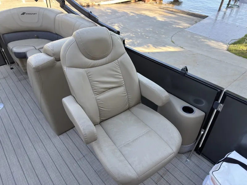 Slide: The Image of A beige, cushioned captain's chair on a boat with wood flooring and a cup holder. - 18