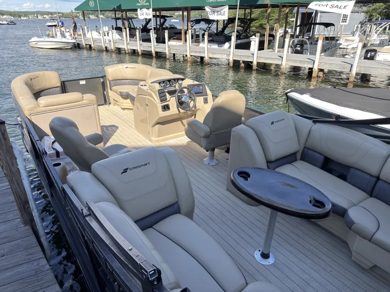 Slide: The Image of The image shows a 2019 Starcraft SLS 3 pontoon boat with luxurious seating and a table. - 30