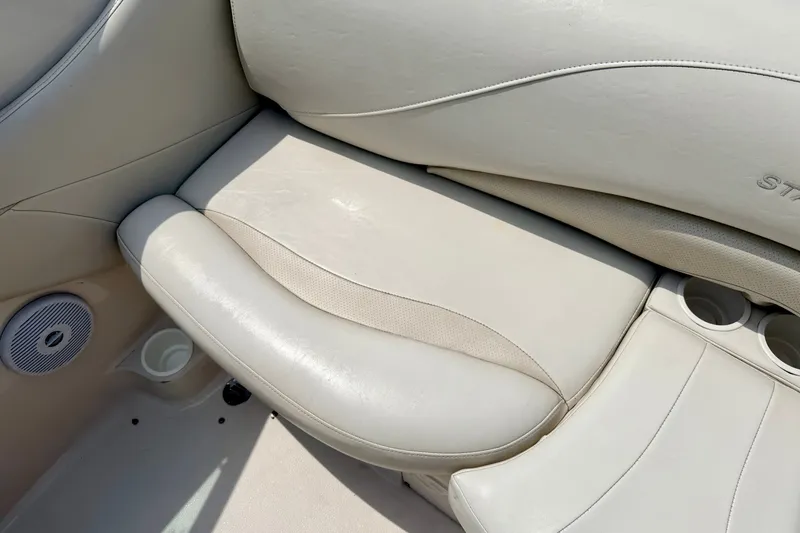 Slide: The Image of 2005 Starcraft 2100 IO RE Limited boat interior with beige leather seating and cup holders. - 37