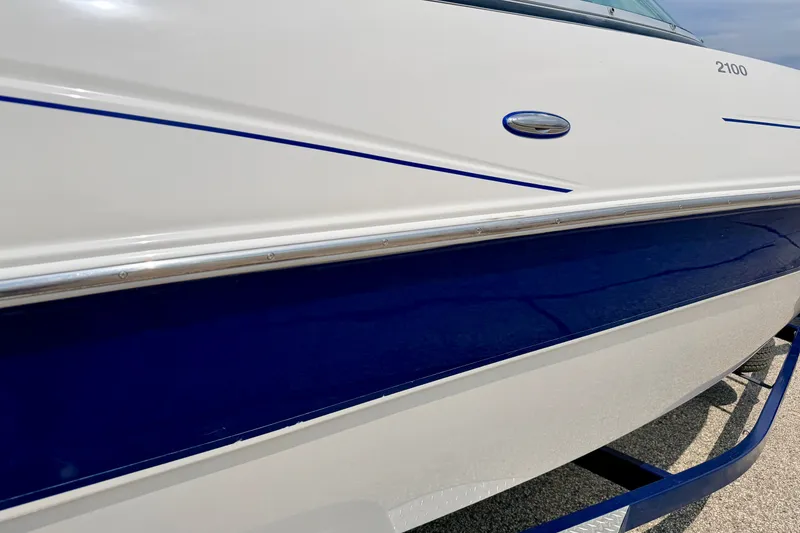 Slide: The Image of 2005 Starcraft 2100 IO RE Limited boat, white and blue exterior detail. - 14