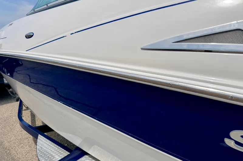 Slide: The Image of 2005 Starcraft 2100 IO RE Limited boat, white and blue exterior detail. - 7