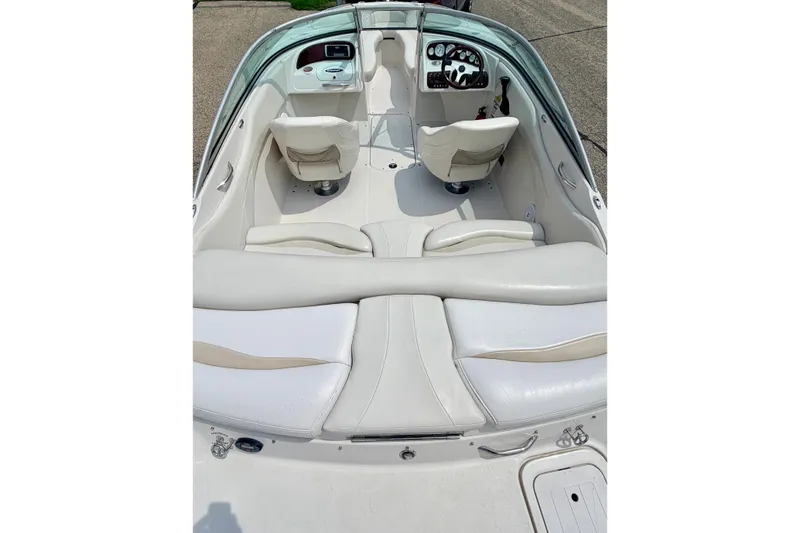 Slide: The Image of 2005 Starcraft 2100 IO RE Limited boat interior with white seating and dashboard view. - 26