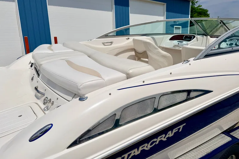Slide: The Image of 2005 Starcraft 2100 IO RE Limited boat with white seating and sleek design. - 17