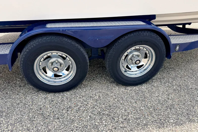 Slide: The Image of Trailer wheels of a 2005 Starcraft 2100 IO RE Limited boat on pavement. - 83