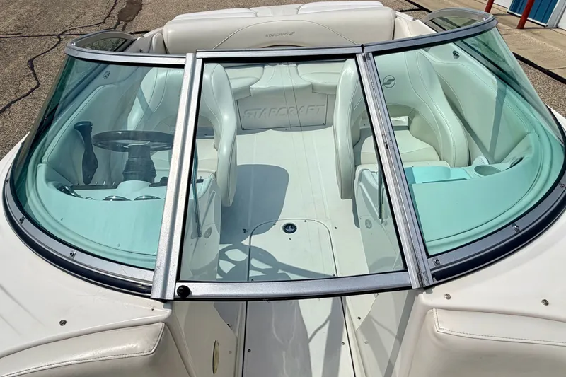 Slide: The Image of 2005 Starcraft 2100 IO RE Limited boat interior with white seating and steering wheel. - 70