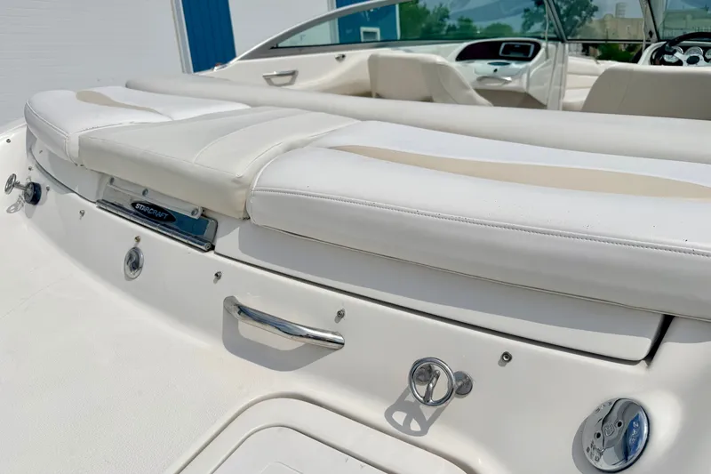 Slide: The Image of 2005 Starcraft 2100 IO RE Limited boat interior with white seating and chrome details. - 25