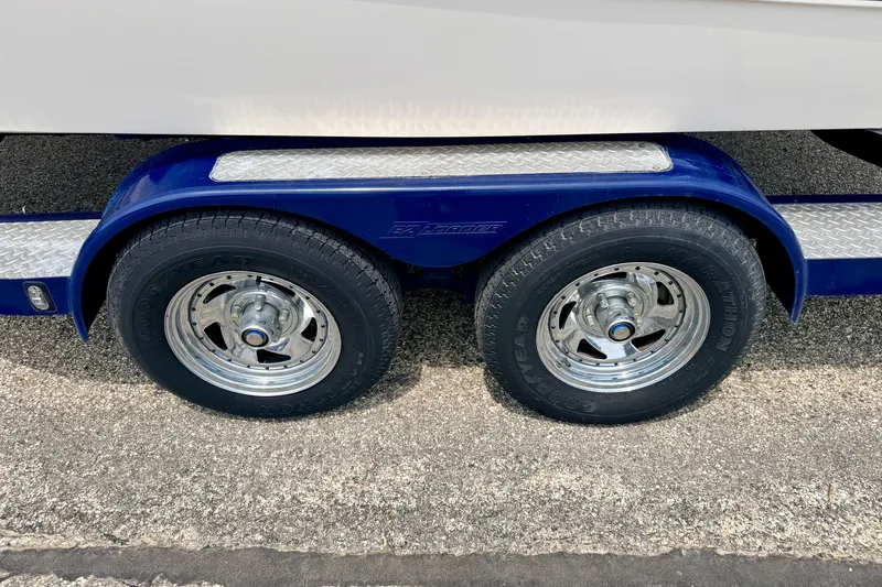 Slide: The Image of Trailer wheels of a 2005 Starcraft 2100 IO RE Limited boat on pavement. - 81