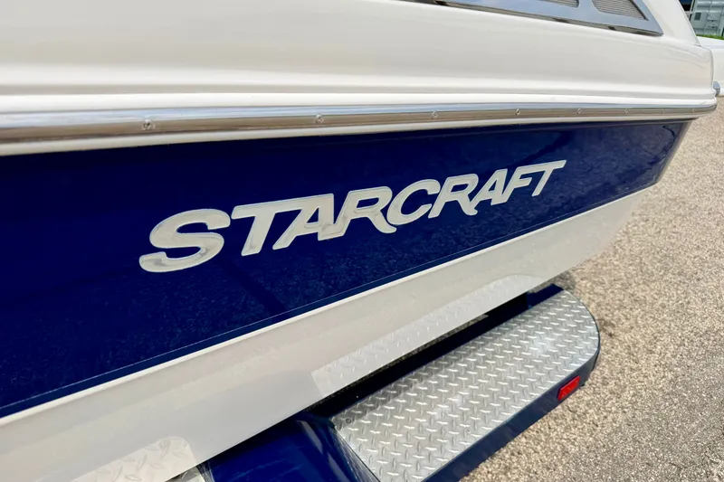 Slide: The Image of 2005 Starcraft 2100 IO RE Limited boat, blue and white exterior, close-up view. - 6