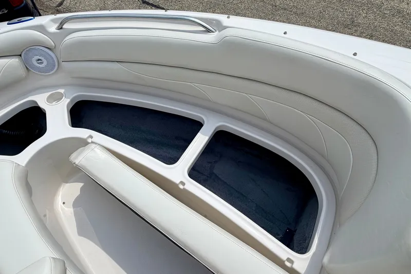 Slide: The Image of Interior seating of 2005 Starcraft 2100 IO RE Limited boat, featuring white upholstery and storage compartments. - 64