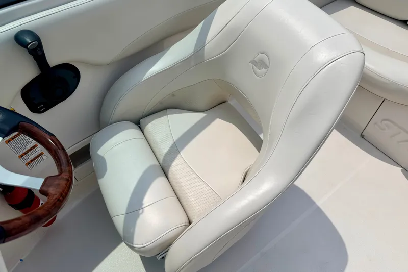 Slide: The Image of 2005 Starcraft 2100 IO RE Limited boat seat with steering wheel, featuring white upholstery. - 50
