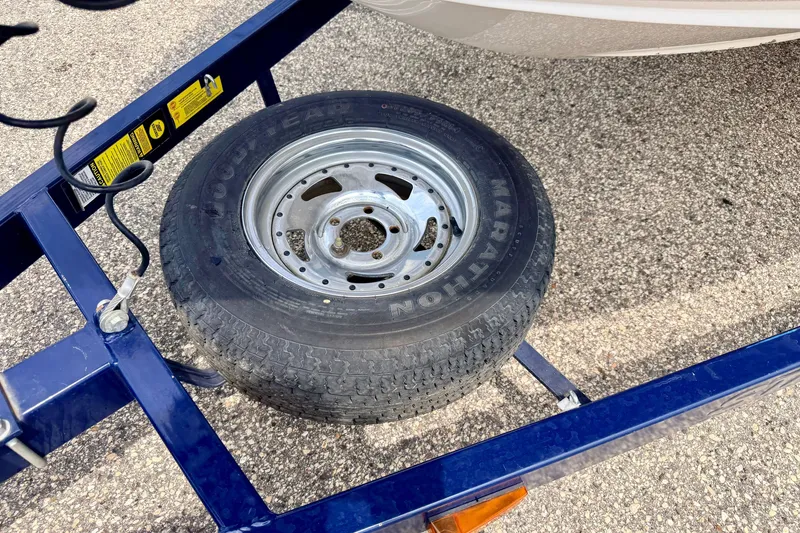 Slide: The Image of Trailer tire on a Starcraft 2100 IO RE Limited, 2005 model, parked on asphalt. - 77
