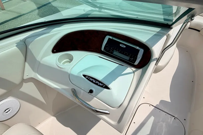 Slide: The Image of Interior of 2005 Starcraft 2100 IO RE Limited boat, featuring dashboard and stereo system. - 54