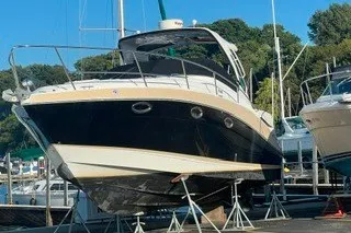 Slide: The Image of 2013 Four Winns V335 boat docked on stands in a marina setting. - 2