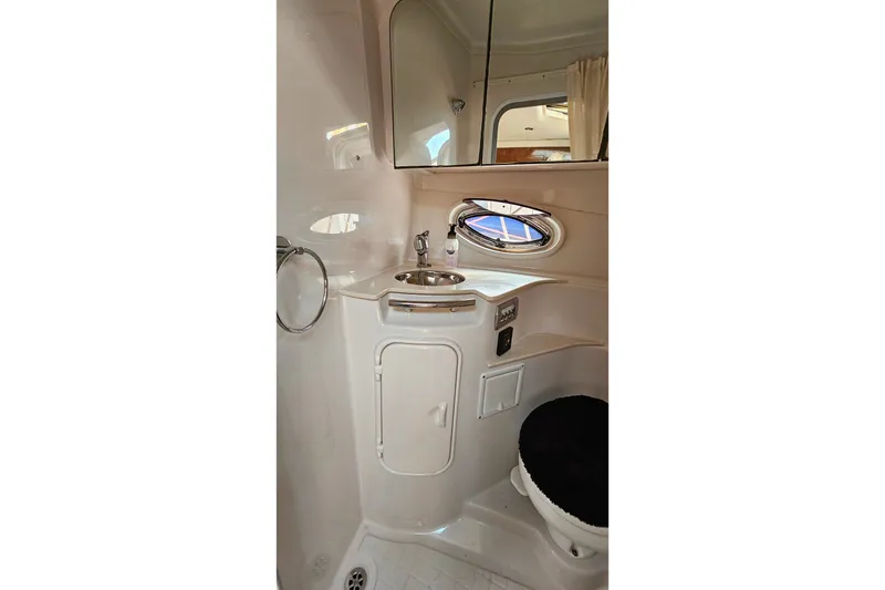 Slide: The Image of 2013 Four Winns V335 boat bathroom with sink, mirror, and porthole window. - 18