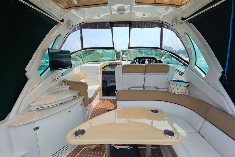 Slide: The Image of Interior of 2013 Four Winns V335 boat with seating, table, and mounted TV. - 30