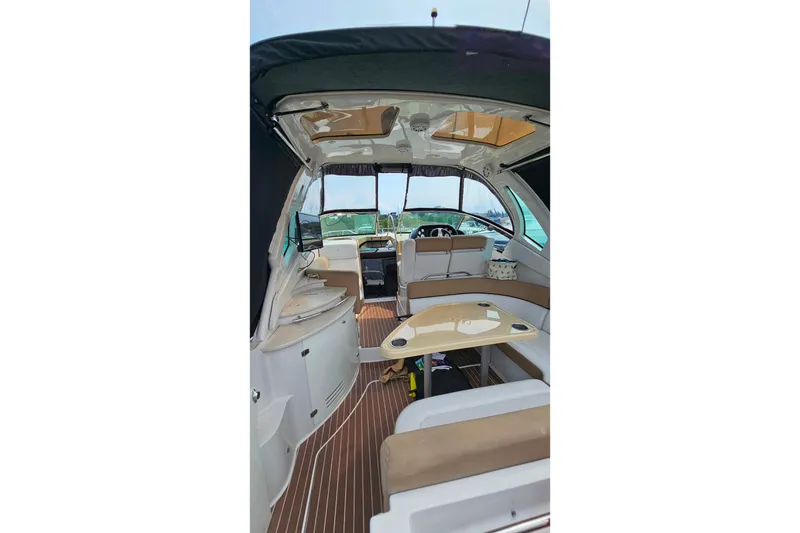 Slide: The Image of Interior of 2013 Four Winns V335 boat with seating and table, featuring a sleek design. - 26