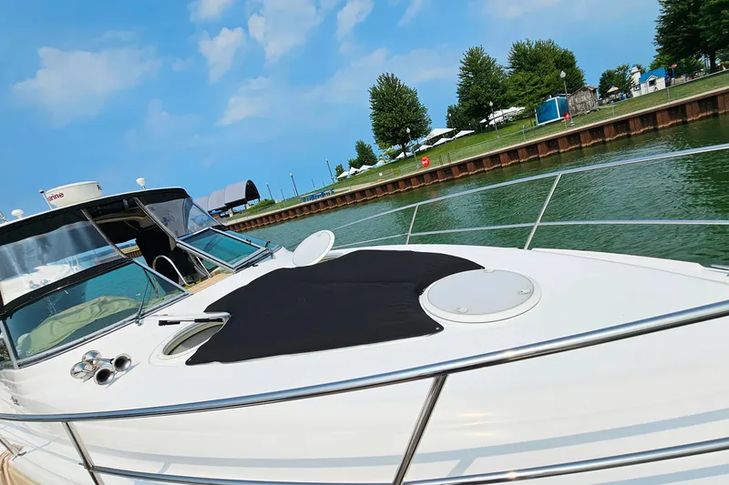 Slide: The Image of 2013 Four Winns V335 boat docked by a scenic waterfront with clear skies. - 48