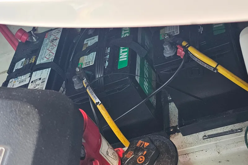 Slide: The Image of Battery compartment of a 2013 Four Winns V335 boat, showing connected cables and terminals. - 65