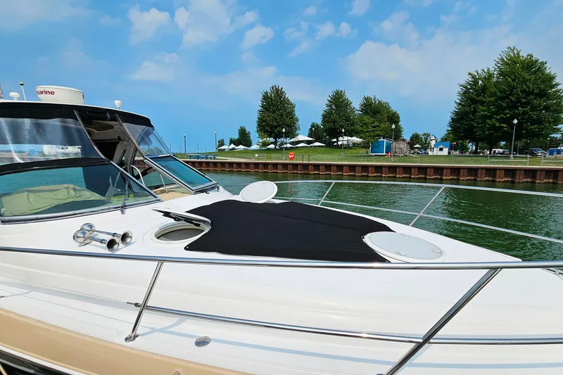 Slide: The Image of 2013 Four Winns V335 boat docked by a scenic waterfront with trees and blue sky. - 51