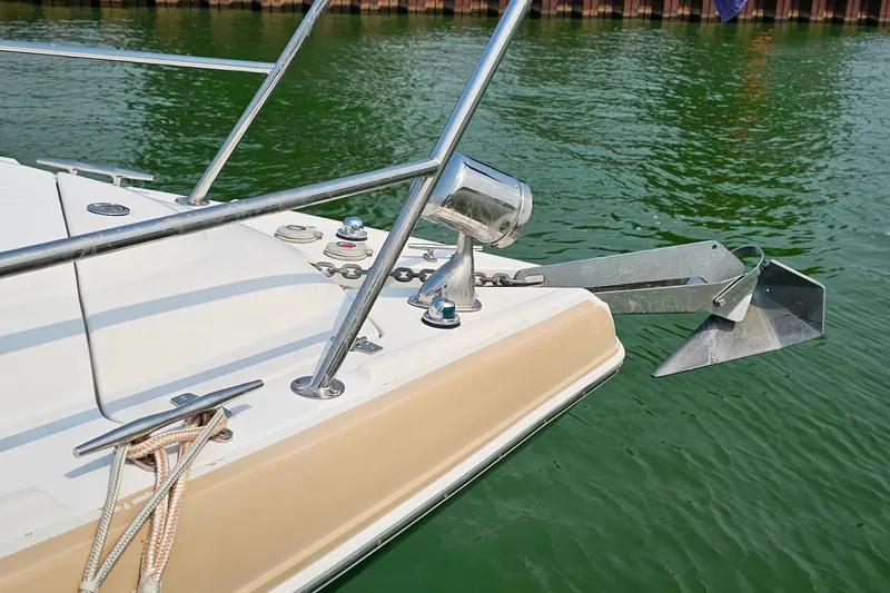 Slide: The Image of Bow of 2013 Four Winns V335 boat with anchor, docked on green water. - 49
