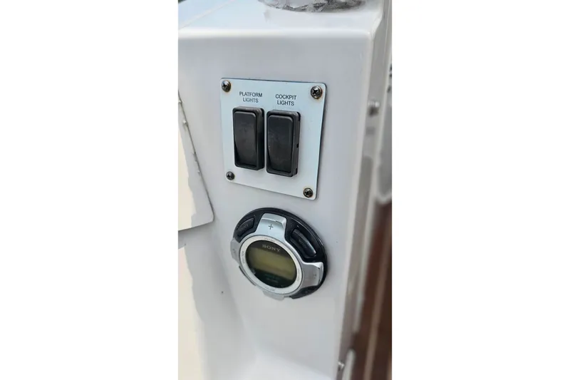 Slide: The Image of Control panel of a 2013 Four Winns V335 boat with light switches and Sony audio control. - 57