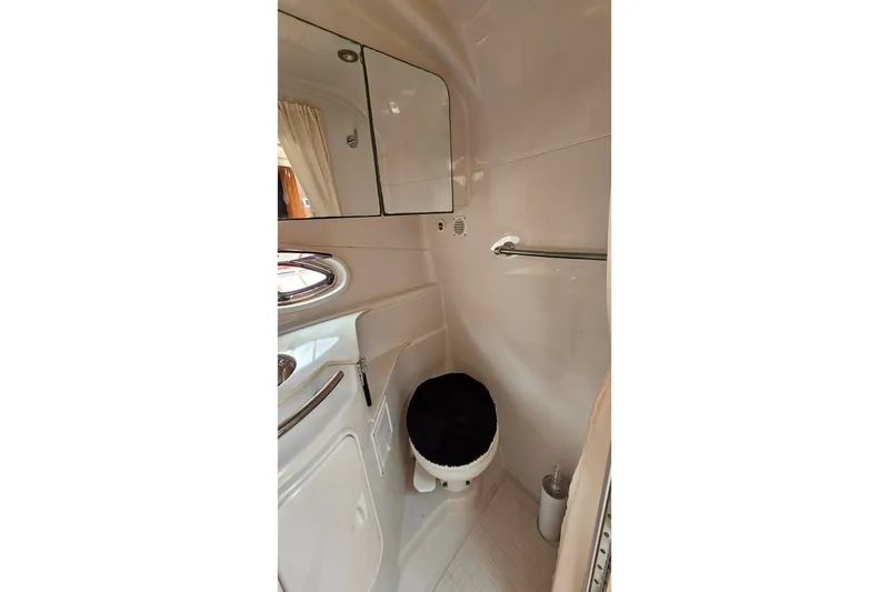 Slide: The Image of 2013 Four Winns V335 yacht bathroom with mirror, toilet, and towel rack. - 17