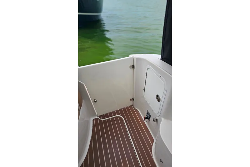 Slide: The Image of 2013 Four Winns V335 boat interior with wood-patterned flooring and water view. - 59