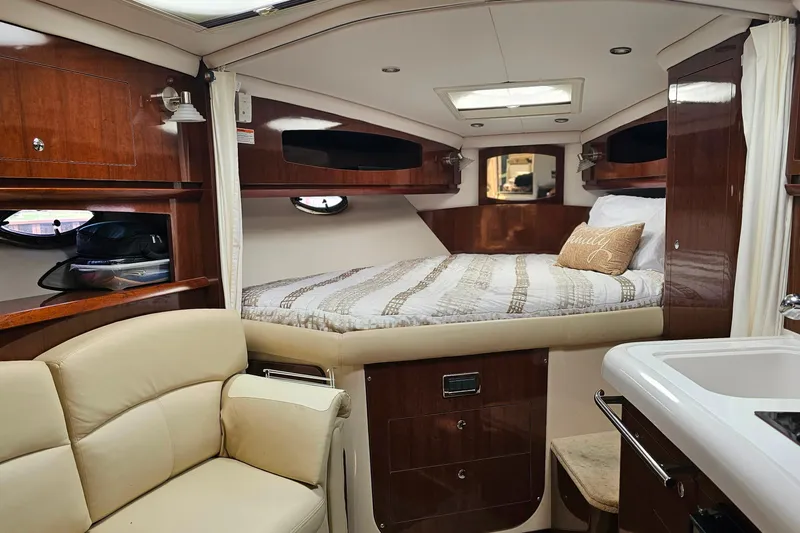 Slide: The Image of Luxurious 2013 Four Winns V335 cabin interior with cozy bed and elegant wood finish. - 8