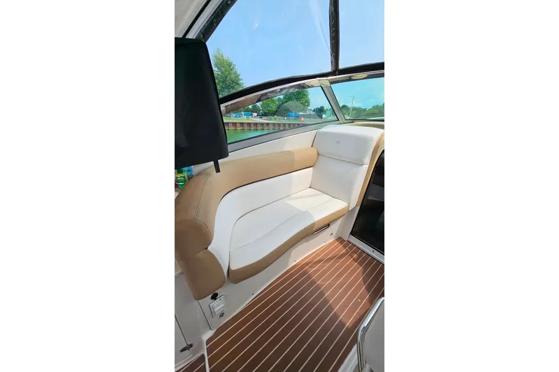 Slide: The Image of Interior of 2013 Four Winns V335 boat with beige and white seating, wooden flooring. - 32