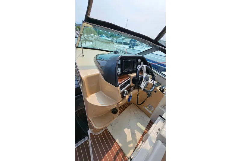 Slide: The Image of 2013 Four Winns V335 boat cockpit with steering wheel and control panel. - 42