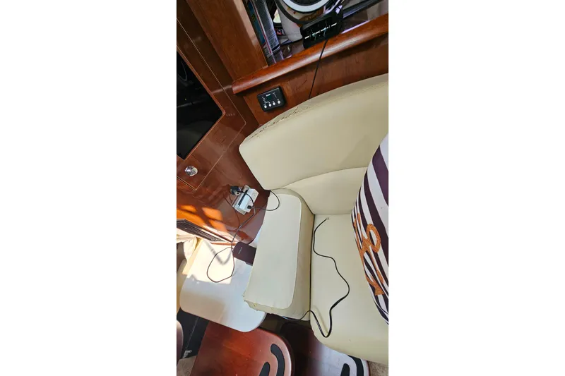 Slide: The Image of Interior of 2013 Four Winns V335 boat with beige seating and striped pillow. - 21