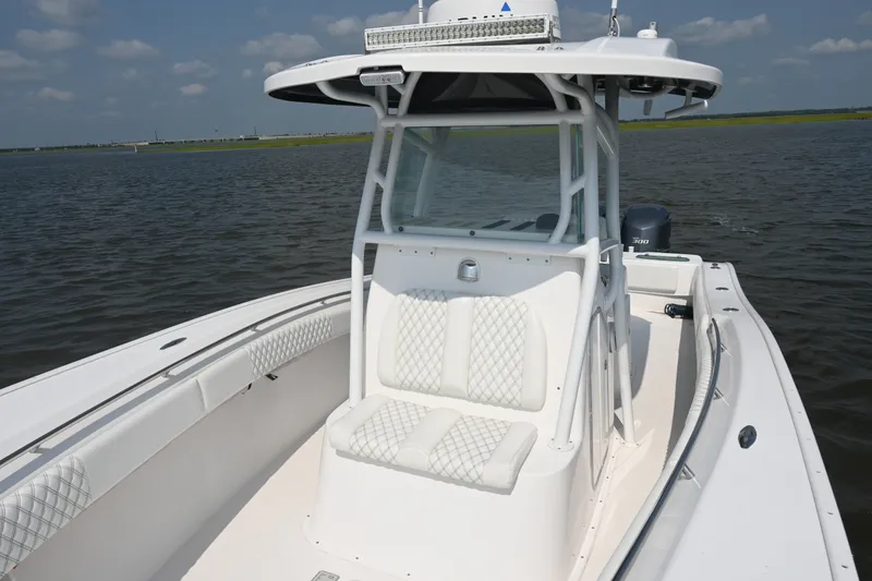 Slide: The Image of 2015 Cape Horn 31T boat with white seating, on calm water under a blue sky. - 17