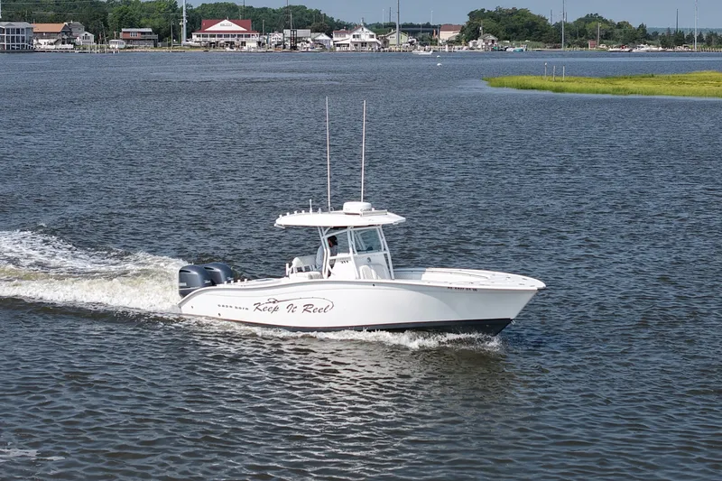 Slide: The Image of 2015 Cape Horn 31T boat cruising on a calm river near a coastal town. - 9