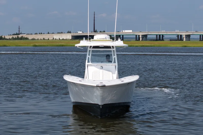 Slide: The Image of 2015 Cape Horn 31T boat cruising on a calm river near a bridge. - 2