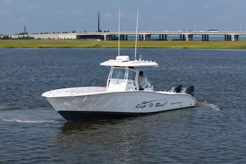 Slide: The Image of 2015 Cape Horn 31T boat cruising on a calm river near a bridge. - 1