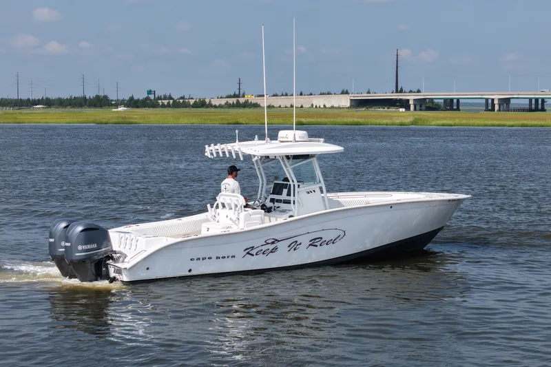 Slide: The Image of 2015 Cape Horn 31T boat cruising on a calm river with a bridge in the background. - 5