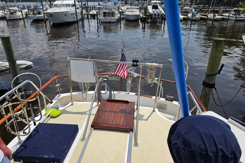 Slide: The Image of 1983 Monk 36 boat docked at marina with American flag and nautical equipment. - 4